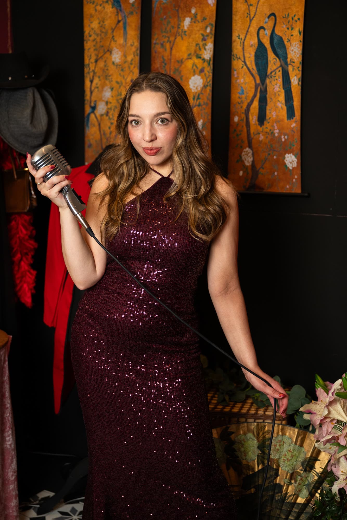 Olivia holding a vintage microphone in a sequinned dress