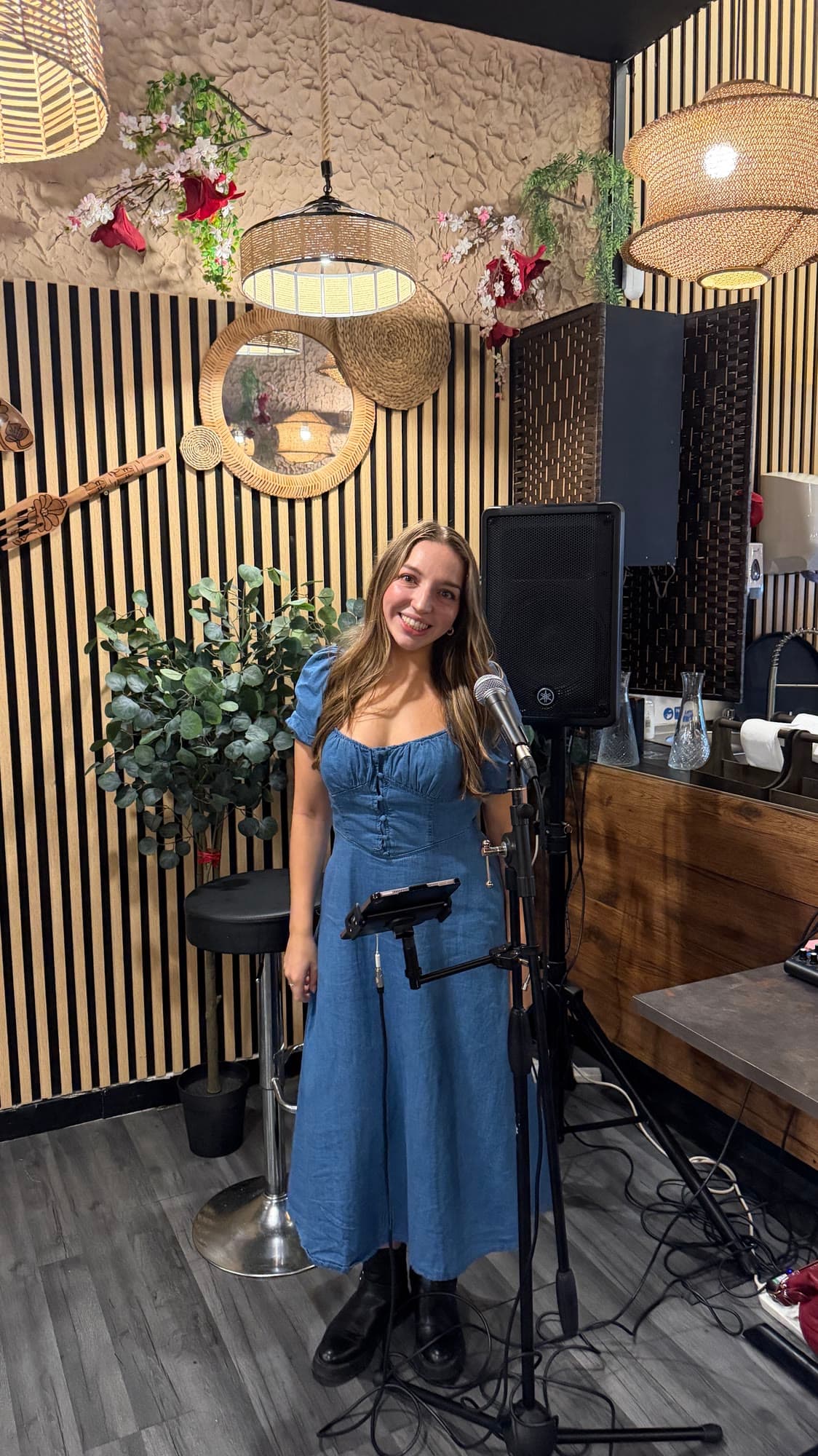 Olivia smiling at the microphone before a set in a bar
