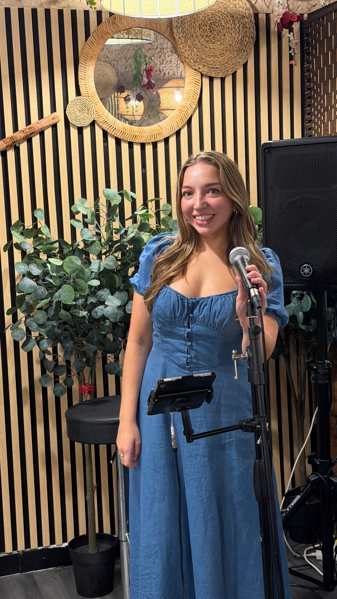 Olivia performing at a microphone stand in a stylish bar